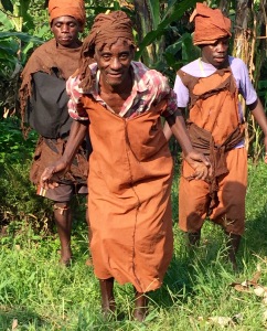 Batwa men dancing to the beat of drums and singing