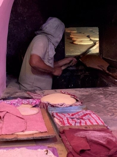 The baker turns the bread.