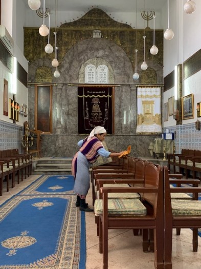 As we sit quietly in the synagogue, a lady lovingly dusts the chairs.