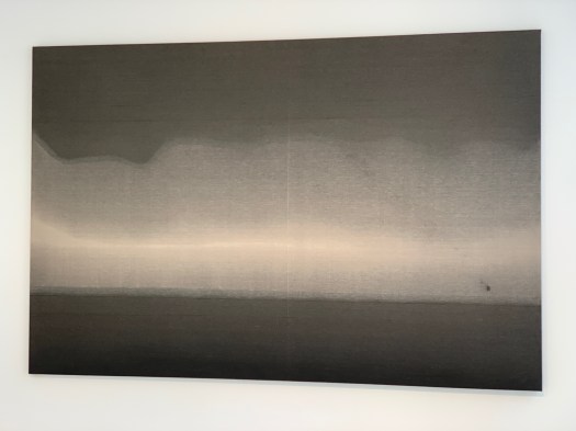 Two canvases using motor oil. The first gives an image of dark sea and sky.