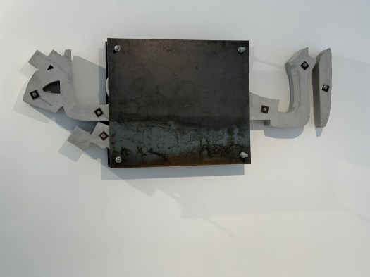 A concrete and steel sculpture that reads, in Arabic, "Liberty." However, the word is in concrete nailed to the wall with a steel plate over the middle of it. The message is that Liberty has not become free. I found this piece very visceral.