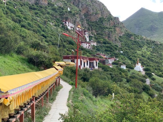 A path of prayer wheels leading to another cluster of caves.