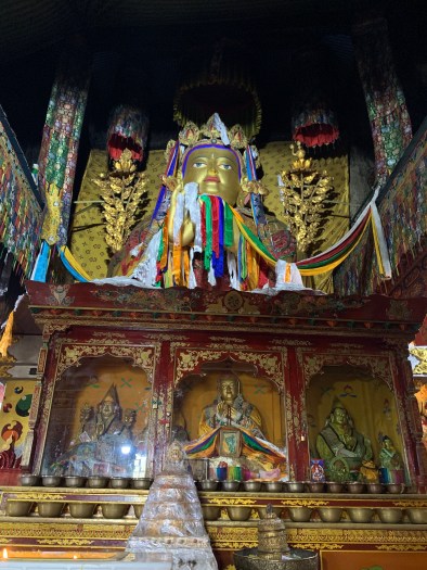 Buddhas tucked into the blackened rock of an ancient cave.
