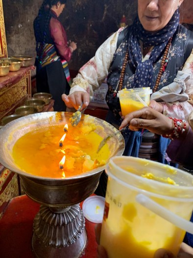 Ladies adding hot wax butter to a candle holder